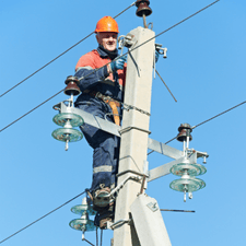 An experienced electrical technician working on power lines.