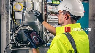 An electrical technician works on a cable box in a smart home.