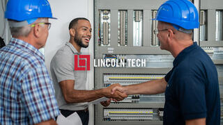 Skilled technicians standing in a electrical access area discussing work.