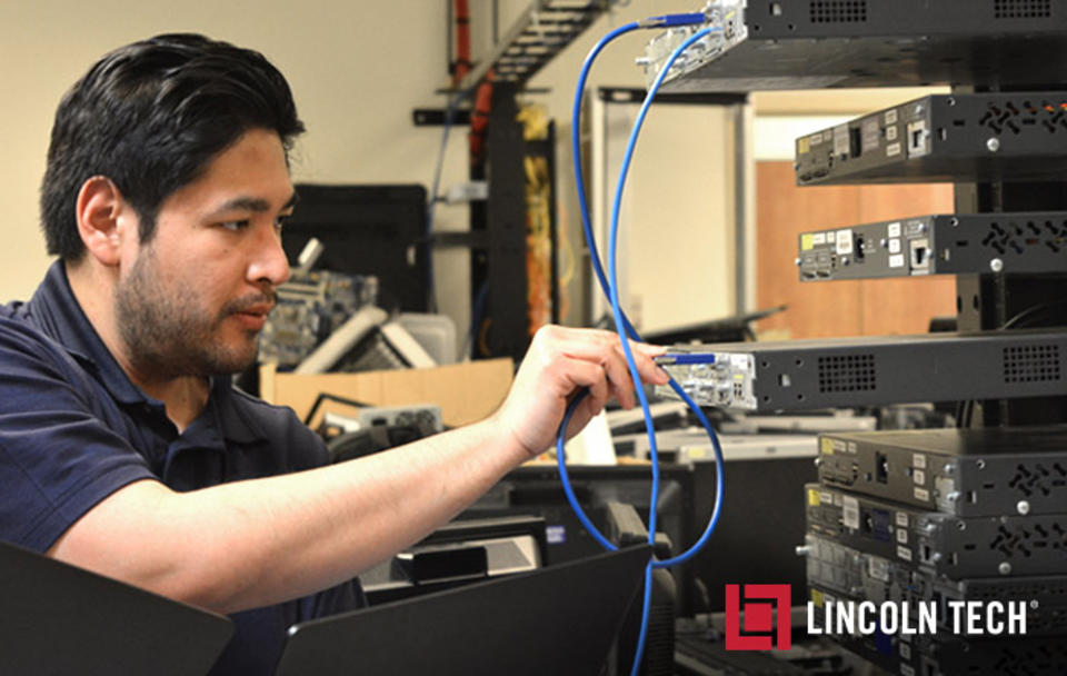 An information technology student sets up a server rack system