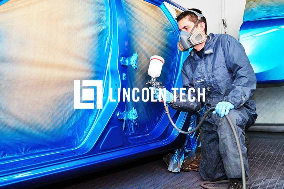Student painting an automobile during the refinishing process.