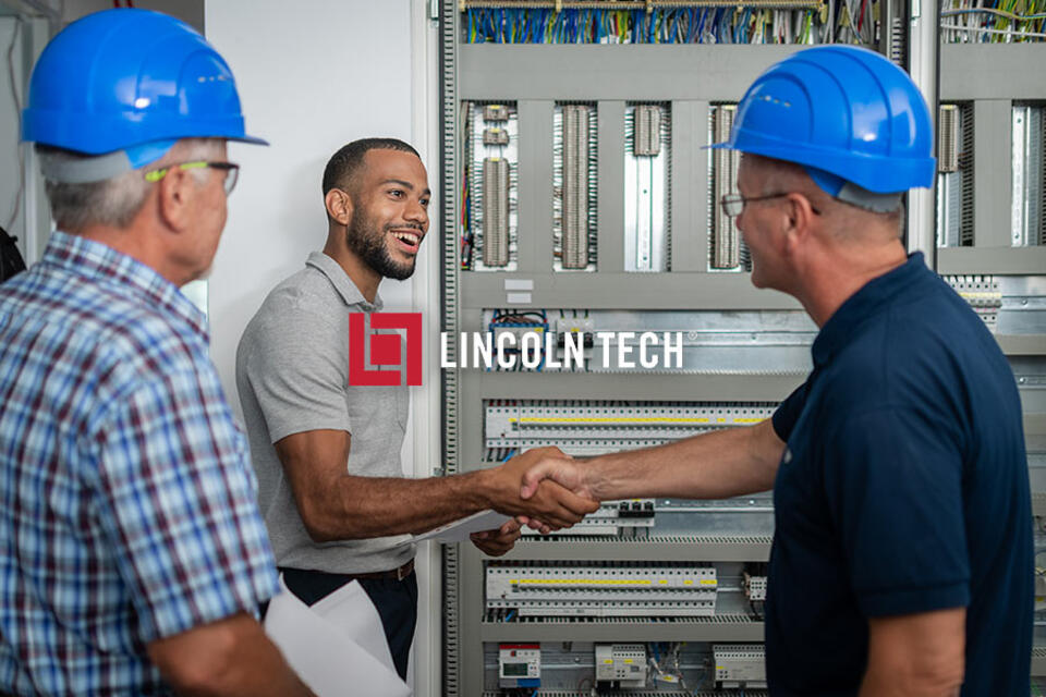 Skilled technicians standing in a electrical access area discussing work.