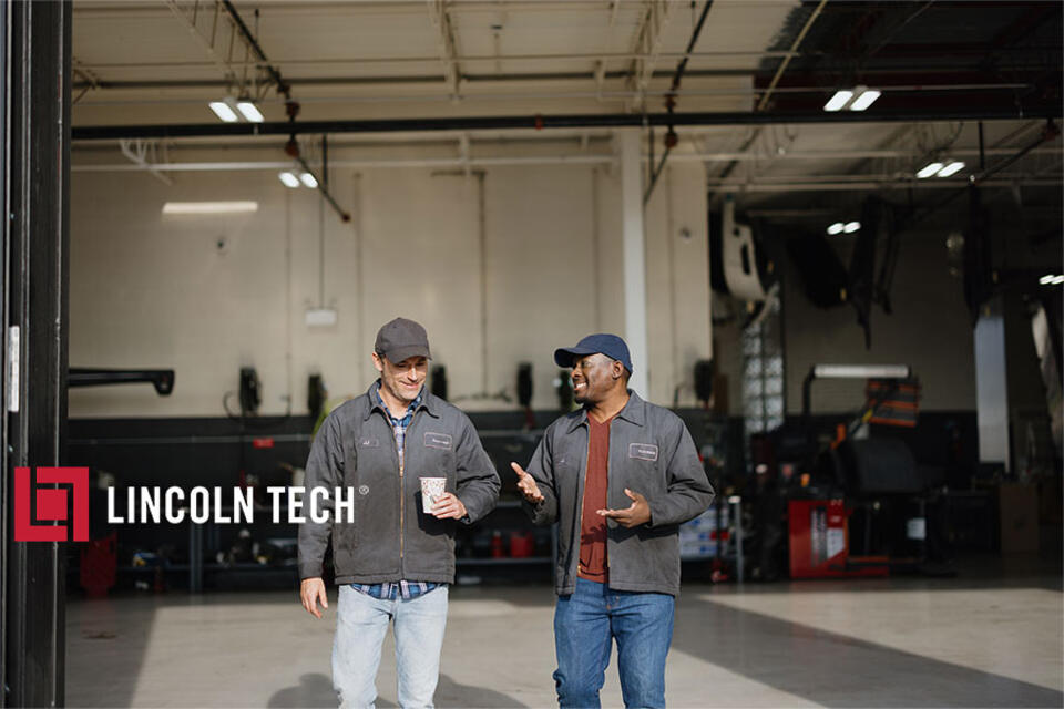 Two mechanics leaving a repair shop.